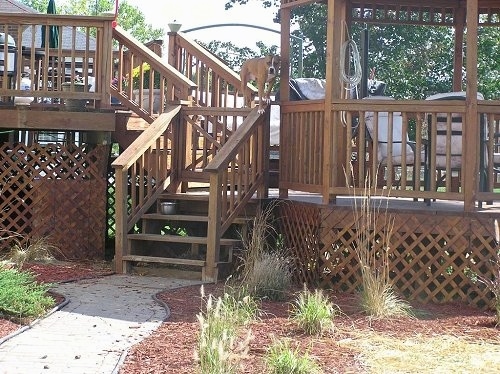 Petey the Pit Bull is standing on a wooden railing next to a Gazebo