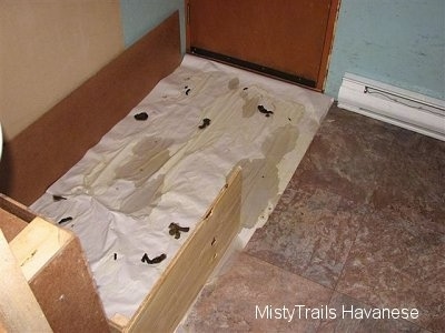 A freshly used potty area of a whelping box.