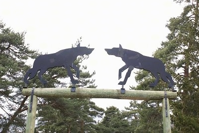 Two iron Wolf silhouettes over a wooden entrance way.