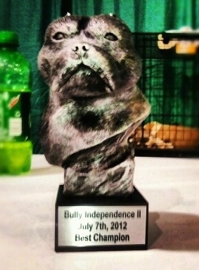 A trophy with the face of an American Bully on it. The plaque reads - Bully Independence II July 7th,2012 Best Champion.