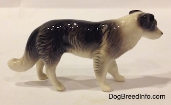 The right side of a Retired Hagen-Renaker black with white Border Collie style 1 figurine. It is hard to differentiate the ears from the head.