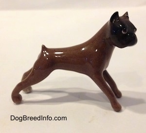The left side of a brown with black Boxer dog figurine.