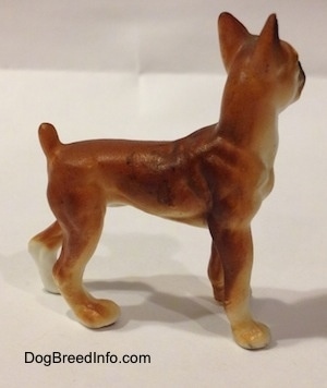 The right side of a bone china brown with white and black Boxer dog figurine. The figurine has great paw details.