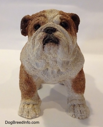 A brown and white ceramic mold of a Bulldog figurine. The figurine has black circles for eyes.