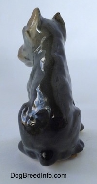 The back of a grey with black and tan Cane Corso Italiano puppy figurine. The figurine has a short tail.