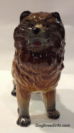 A porcelain brown with black Chow Chow figurine. The figurine has small black circles for eyes.