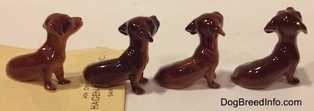 The right side of four Dachshund Pup Seated figurines. The figurines are glossy.
