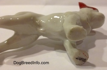 The underside of a bone china French Bulldog figurine that has a Japan stamp on its front left paw.