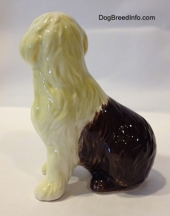 The left side of a brown with white porcelain figurine of an Old English Sheepdog. The figurine has fine hair details.