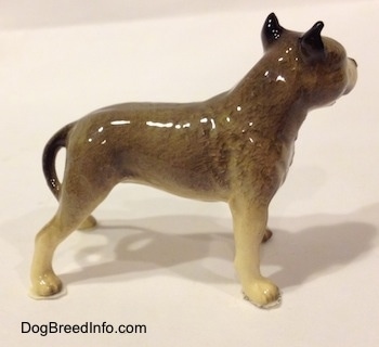 The right side of a black, gray and white figurine of a Pit Bull Terrier. The figurine has black ears.