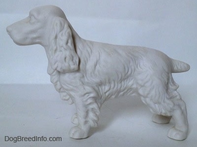 The left side of an unpainted white bisque Welsh Springer Spaniel. The figurine has fine hair details along its body.