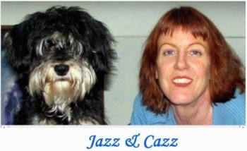 Close up - A black with white Miniature Schnoodle is sitting on a carpet and it is looking forward, next to a lady that is looking forward. The words - Jazz & Cazz - are overlayed in the middle of a white block at the bottom of the image. The lady and the dog are making similar faces and have similar haircuts