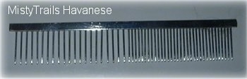 Close up - a metal comb with the pins closer together on one end and further apart on the other.
