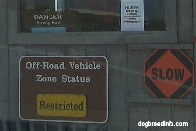 Booth with signs on it 'Off-Road Vehicle szone Status Restricted', 'Slow', 'Danger Strong Surf'