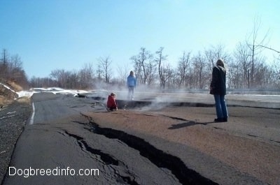 Three People standing on a steaming cracked road