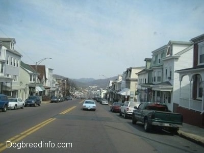 A picture of a neighboring coal town named Ashland with row homes of houses and cars on each side of the street