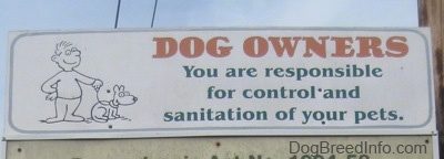 A sign that reads - DOG OWNERS You are responsible for control and sanitation of your pets.