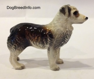 The right side of a black and white Australian Shepherd figurine. The figurine has detailed eyes.