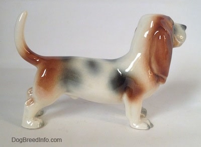 The right side of a white with black and red Basset Hound figurine. The figurine does not have excessive details.