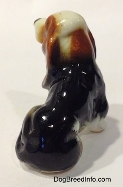 The back of a brown, black and white ceramic Basset Hound figurine.
