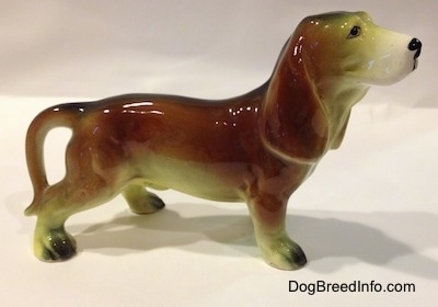 The right side of a brown with white and black ceramic Basset Hound figurine. The figurine has great detail.