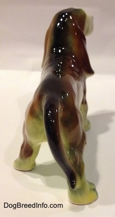 The back of a brown with white and black ceramic Basset Hound figurine. The figurine has a detailed tail.
