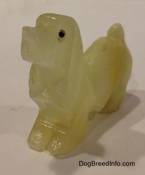 The front left side of a stone Basset Hound figurine.