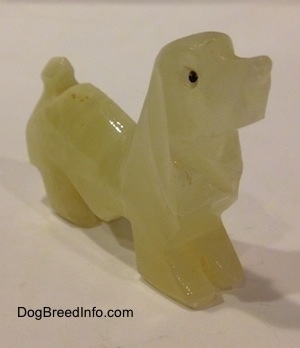 The front right side of a stone Basset Hound figurine.