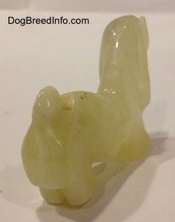 The back right side of a stone Basset Hound figurine.