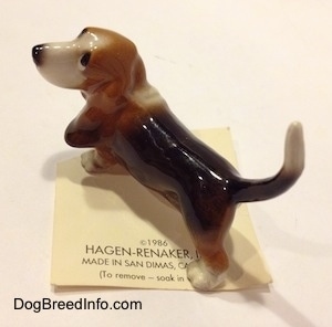 Topdown view of a black and brown with white Basset Hound figurine. The figurine has fine details.