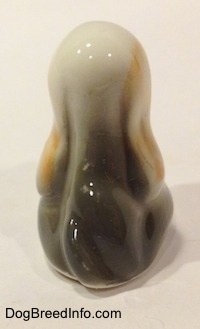 The back of a white with tan and black bone china Basset Hound puppy figurine. The figurine has a nice shape going down its back.
