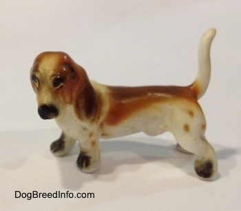 The left side of a brown and white porcelain Basset Hound figurine. The face of the figurine lacks fine detal.