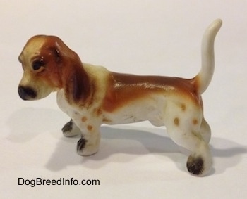 The left side of a brown and white porcelain Basset Hound figurine. The figurine has great details.