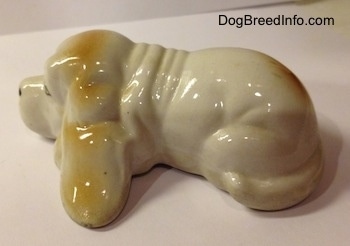 The left side of a white with tan porcelain Basset Hound figurine.