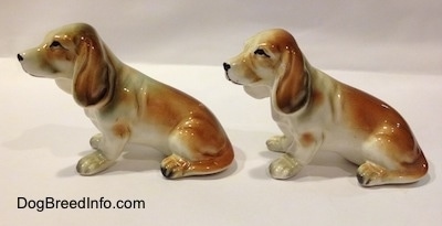 The left side of two brown and white with black ceramic Basset Hound figurines. The figurines have great ear details.