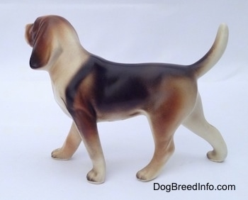 The left side of a black, brown and white porcelain Beagle Harrier figurine in a standing pose. The painting on the figurine is great.