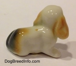 The back of a bone china white with tan and black tiny Beagle puppy figurine.