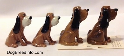 The right side of a line up of four Hagen-Renaker Bloodhound figurines.