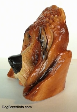 The left side of a highly detailed figurine of the head of a Bloodhound dog. The figurine has fine hair details on its nose.