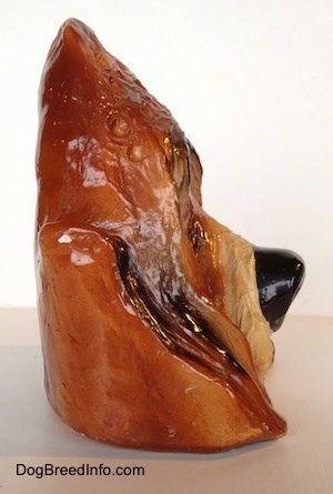 The right side of a highly detailed figurine of the head of a Bloodhound dog. The figurine has bumps on the forehead.