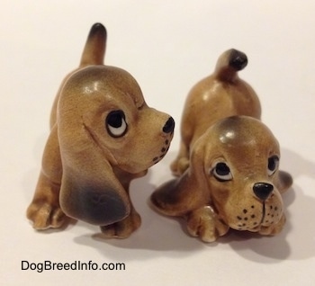 Two Vintage miniature ceramic Bloodhound figurines. The whiskers on the figurines face are dots.