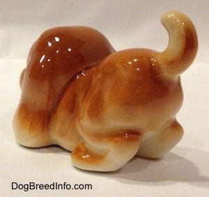 The back left side of a tan Cartoon style Bloodhound puppy. The figurine is glossy.