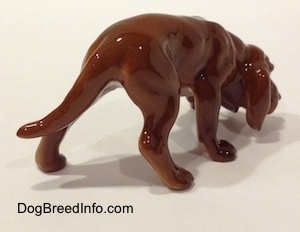 The back right side of a Hagen-Renaker miniature red variation of a Bloodhound figurine. The figurine is very detailed.