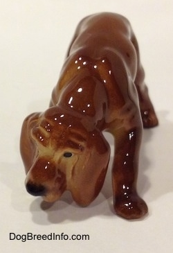 A Hagen-Renaker miniature red variation of a Bloodhound figurine. The figurine has great wrinkles on the face details.
