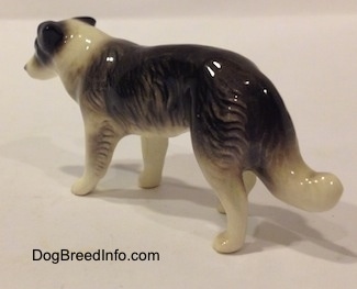 The back left side of a Retired Hagen-Renaker black with white Border Collie style 1 figurine. The paws of the figurine are not very detailed.
