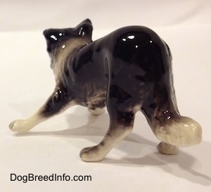 The back left side of a Hagen-Renaker miniature black with white Border Collie figurine. Its hard to tell the difference from the tail and the body of the figurine.