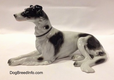 The left side of a white with black vintage TMK-1 crown mark Borzoi. The eyes of the figurine are hard to see.