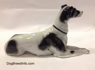 The right side of a white with black vintage TMK-1 crown mark Borzoi. The figurine is glossy. The dog has short small ears, a long neck and a thin black collar.