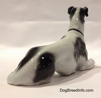 The back right side of a white with black vintage TMK-1 crown mark Borzoi. The figurine has a finely shaped body.