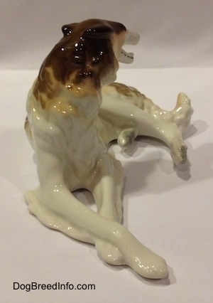 A brown, white and tan Vintage porcelain Lomonosov Borzoi figurine. The chest of the figurine has a very detailed chest.
